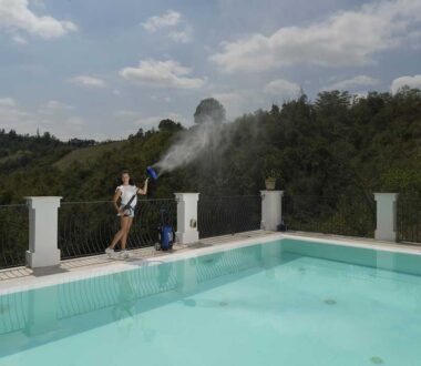 donna che pulisce piscina con idropulitrice