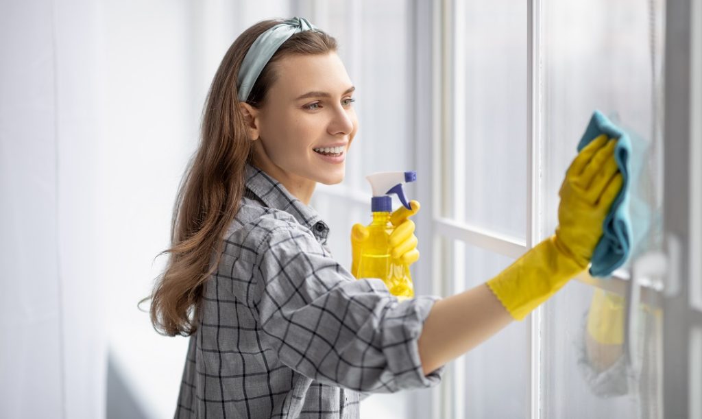 donna pulisce vetri finestre