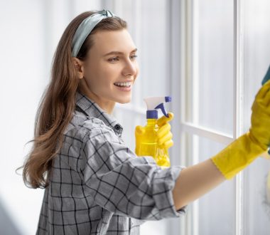 donna pulisce vetri finestre